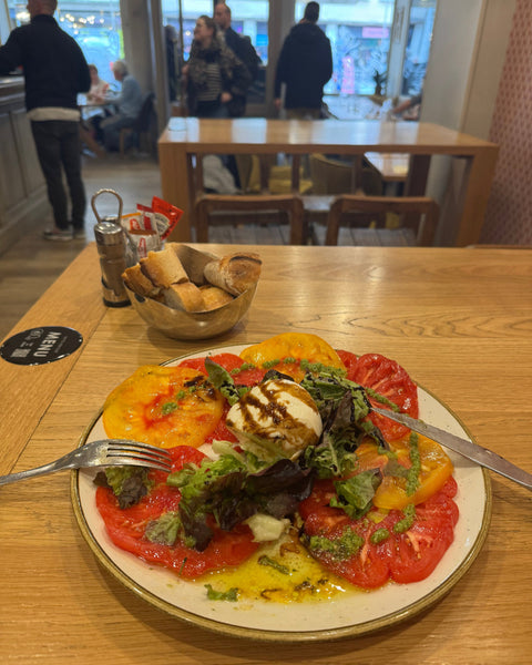 Entrée estivale à la Brasserie Le Cathédrale Gourmand à Chartres : burrata crémeuse servie avec des tomates anciennes colorées, pesto frais et salade, accompagnée de pain croustillant.