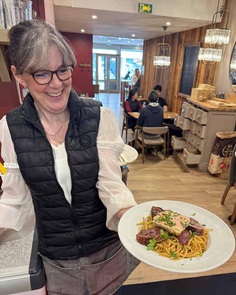 Présentation d’un plat de pâtes fait maison par une serveuse souriante au restaurant Le Cathédrale Gourmand à Chartres.