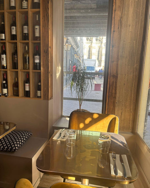 Table en coin avec vue sur la rue et mur de vins au restaurant Le Cathédrale Gourmand à Chartres – idéale pour un dîner en duo ou une pause cosy