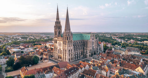 Vue aérienne de la majestueuse Cathédrale de Chartres, entourée de la ville historique, un symbole de charme et d’authenticité pour une expérience culinaire à Le Cathédrale Brasserie.