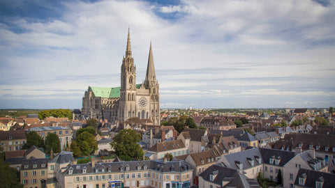 Vue panoramique de Chartres avec la célèbre Cathédrale Notre-Dame sous un ciel lumineux, mettant en valeur le charme et l’histoire de la ville.