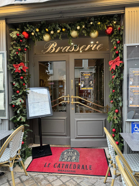 Entrée élégante de La Cathédrale Brasserie à Chartres, décorée de fleurs et d’une ambiance chaleureuse, accueillant les clients pour une expérience culinaire unique.