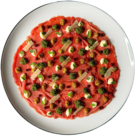 Carpaccio de bœuf finement tranché, garni de roquette, copeaux de parmesan, et une sauce balsamique, servi à la brasserie Le Cathédrale à Chartres.