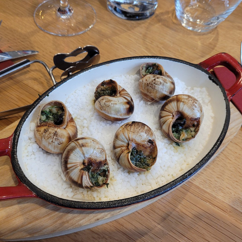 Plat d’escargots traditionnels servis dans une poêle en fonte rouge au restaurant Le Cathédrale Brasserie à Chartres.