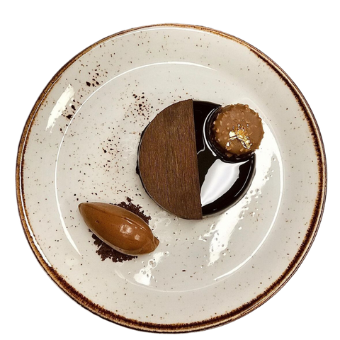  gastronomique élégant servi sur une assiette en céramique, comprenant une mousse au chocolat, une ganache et une décoration artistique, proposé à la brasserie Le Cathédrale.