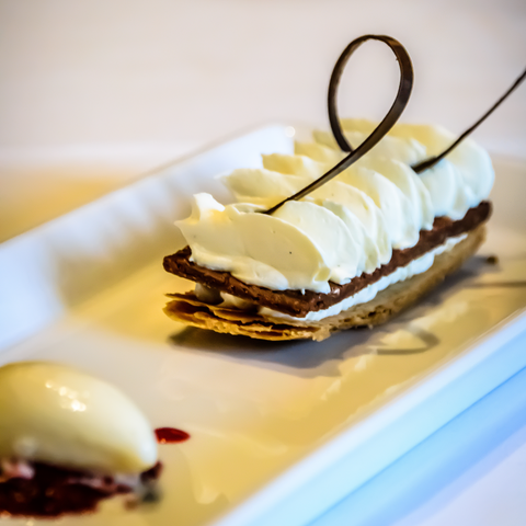 Délicieux mille-feuille gourmand avec une décoration élégante, servi à la brasserie Le Cathédrale, mettant en valeur les desserts raffinés et artistiques.